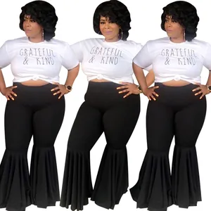 Sexy women's outfit with white graphic t-shirt and black high-waisted ruffle hem flared pants