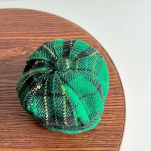 Detailed top view of a British style green plaid pet beret hat featuring metallic gold thread