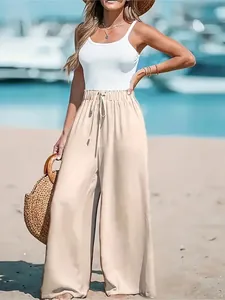 Women's casual wide-leg trousers in beige shown in a sunny beach vacation setting
