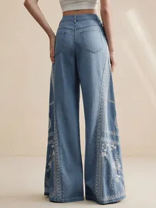 Detailed view of floral embroidery on high-waisted bohemian wide-leg denim jeans