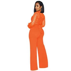 Vista trasera de un elegante mono naranja con lentejuelas, cuello alto y pantalón