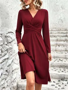 Detail view of twisted waist and V-neckline on this elegant burgundy midi dress.