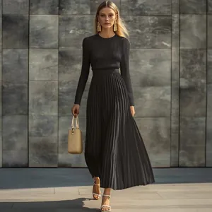 Elegante vestido largo de punto plisado negro con manga larga lucido por una modelo