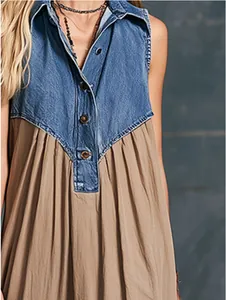 Gedetailleerde weergave van de blauwe denim patchwork en knopen op deze kaki maxi-jurk