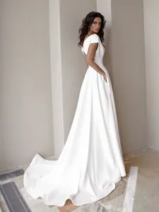 Vista lateral de un elegante vestido blanco largo con espalda abierta y cola larga.