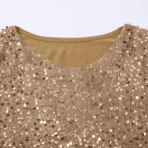 Detailaufnahme eines goldenen Rundhalsoberteils mit schimmernden Paillettenverzierungen.