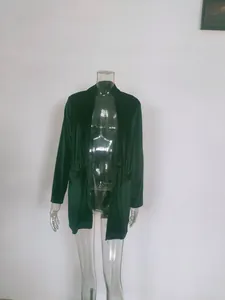 Detail view of a dark green velvet loose-fit jacket with lapels on a mannequin