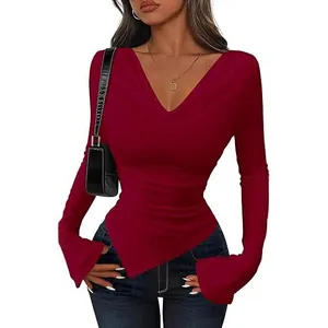 Slim fit burgundy long sleeve women's top with asymmetric hem and elegant V-neck design.