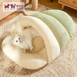 Cozy enclosed green corduroy cat bed with plush lining and white cat resting inside