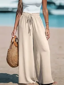 High-waisted beige wide-leg trousers for women in a casual beach lifestyle setting