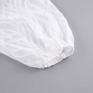 Nahaufnahme des eleganten weißen Jacquard-Stoffes und der elastischen Laternenärmel