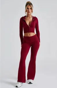 Vista frontale di una donna che indossa un set in maglia a coste bordeaux con pantaloni a zampa.