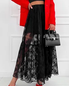 Vue détaillée d'une jupe longue en dentelle noire transparente et d'un blazer rouge chic.