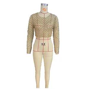 Transparentes goldenes Netz-Crop-Top mit aufwendiger Perlenverzierung an einem Mannequin.