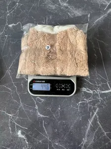 Detailed view of the lightweight plush pet dog winter jacket being weighed on a digital scale