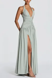 Elegant sage green deep V-neck halter maxi dress with ruched bodice and high slit detail.