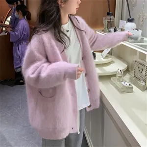 Side view of a soft pink fuzzy faux mink fur cardigan worn by a model in a lifestyle shop
