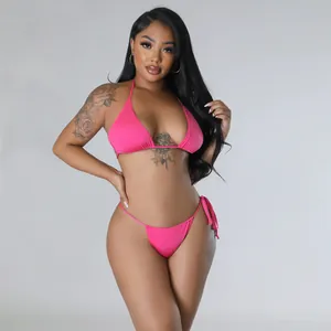 Leuchtendes pinkfarbenes zweiteiliges Neckholder-Bikini-Set an einem Model im Fotostudio