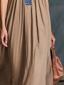 Elegante stedelijke kaki maxi-jurk met een uniek blauw denim patchworkdetail aan de hals.