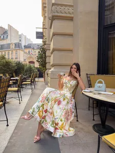 Elegante Frau in einem französischen Vintage-Blumenkleid mit Neckholder in einem Pariser Café