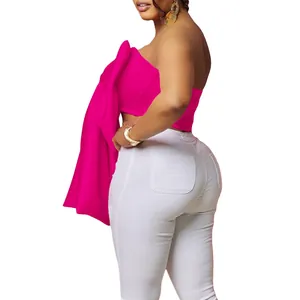 Dettaglio del top a fascia fucsia con spalle scoperte e un grande fiocco decorativo sul lato