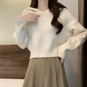 Détail d'un pull en maille douce crème à capuche avec poignets et ourlet côtelés.