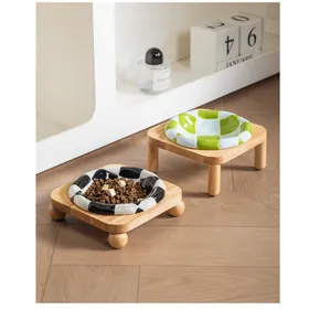 Detailed view of stylish checkered ceramic pet bowls with elevated oak wood stands on floor.
