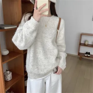 Détail d'un pull en maille blanc doux porté par un mannequin dans un intérieur chaleureux