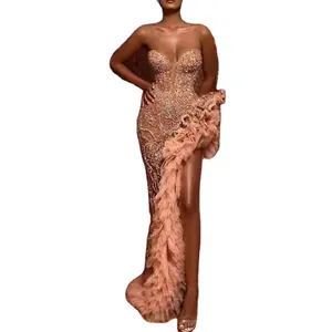 Robe bustier à paillettes dorées avec fente haute et traîne à volants surdimensionnée.