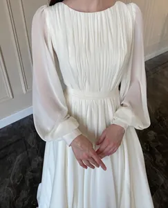 Detailed view of an elegant white lantern-sleeve wedding dress in pearlescent chiffon fabric