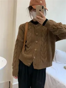 Close-up detail of women's brown retro cable-knit cardigan with large round buttons