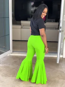 Pantalones de campana verde neón con bajos volantes exagerados y un corte muy ajustado