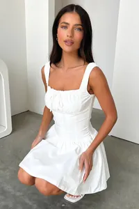 Vue détaillée d'une élégante robe courte blanche avec taille cintrée et bretelles