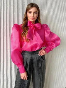 Elegante blusa de malla rosa estilo francés con lazo grande y mangas abullonadas.