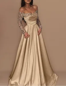 Elegant champagne gold evening gown with long sequined sleeves and pleated satin skirt
