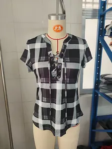 Detail view of a stylish plaid short sleeve top featuring a lace-up V-neck on a mannequin torso