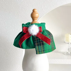 Detail of green plaid Christmas pet collar with a large red glitter bow and pompom