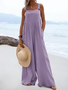 Mono bohemio sin mangas morado con pernera ancha y tirantes con botones en la playa.