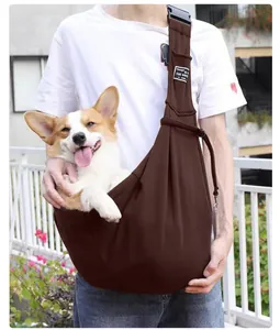 Durable brown pet sling carrier for dogs and cats being worn by a person outdoors