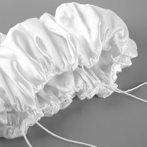Detailed view of white satin ruffled fabric with thin straps for a stylish crop top.