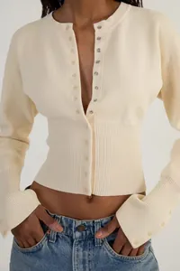 Nahaufnahme einer cremefarbenen, schmal geschnittenen Strickjacke mit Knöpfen