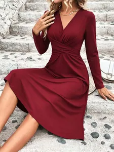 Detailed macro view of burgundy V-neck midi dress featuring an elegant crossover waist design