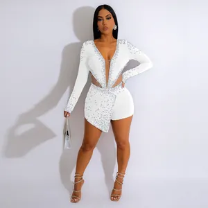 Dettaglio di una tutina sexy bianca in rete con maniche lunghe, strass e perle