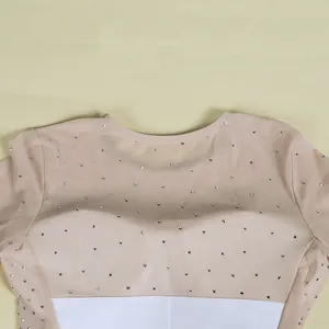 Close-up detail of a beige mesh dress featuring sparkling silver rhinestone embellishments