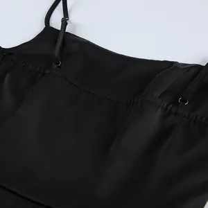 Close-up detail of black satin camisole showing adjustable straps and back elastic
