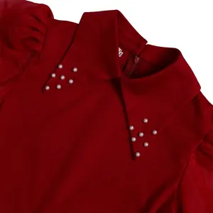 Close-up detail of a red midi dress collar featuring elegant white pearl bead decorations.