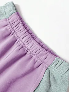 Nahaufnahme des elastischen Bunds an der lila-grauen Jogginghose mit Blockfarben-Design