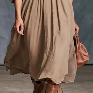 Close-up van elegante kaki lange jurk met natuurlijke stoftextuur en vloeiende rok
