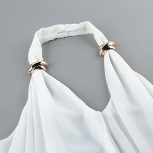 Detail of white chiffon halter top featuring elegant gold metal ring accents