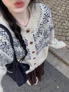 Gros plan détaillé d'un cardigan en maille à motif Fair Isle et boutons en bois rétro